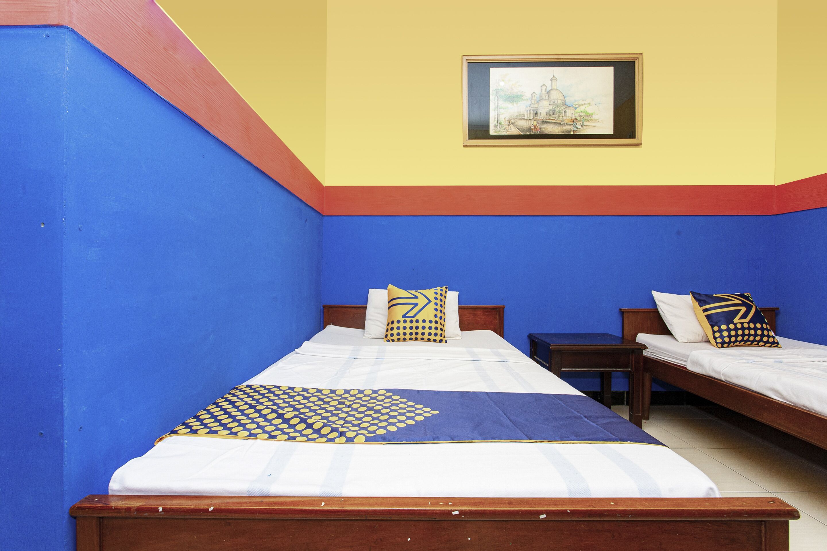 Quarto com duas camas de solteiro, cabeceira de madeira, quadro na parede e decoração em tons de azul e amarelo.