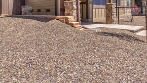 A two-story house with a covered porch, stone steps, and a gravel driveway. - Lovely New Home in the North Woods (Flagstaff)