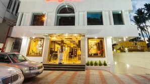A hotel with a prominent 'Chicory Cafe' sign, a modern facade, and a paved entrance area. - Chirag Inn (Thiruvananthapuram)