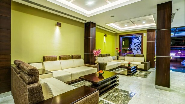 A modern lobby with a sofa set, coffee table, and decorative vase. - Chirag Inn (Thiruvananthapuram)