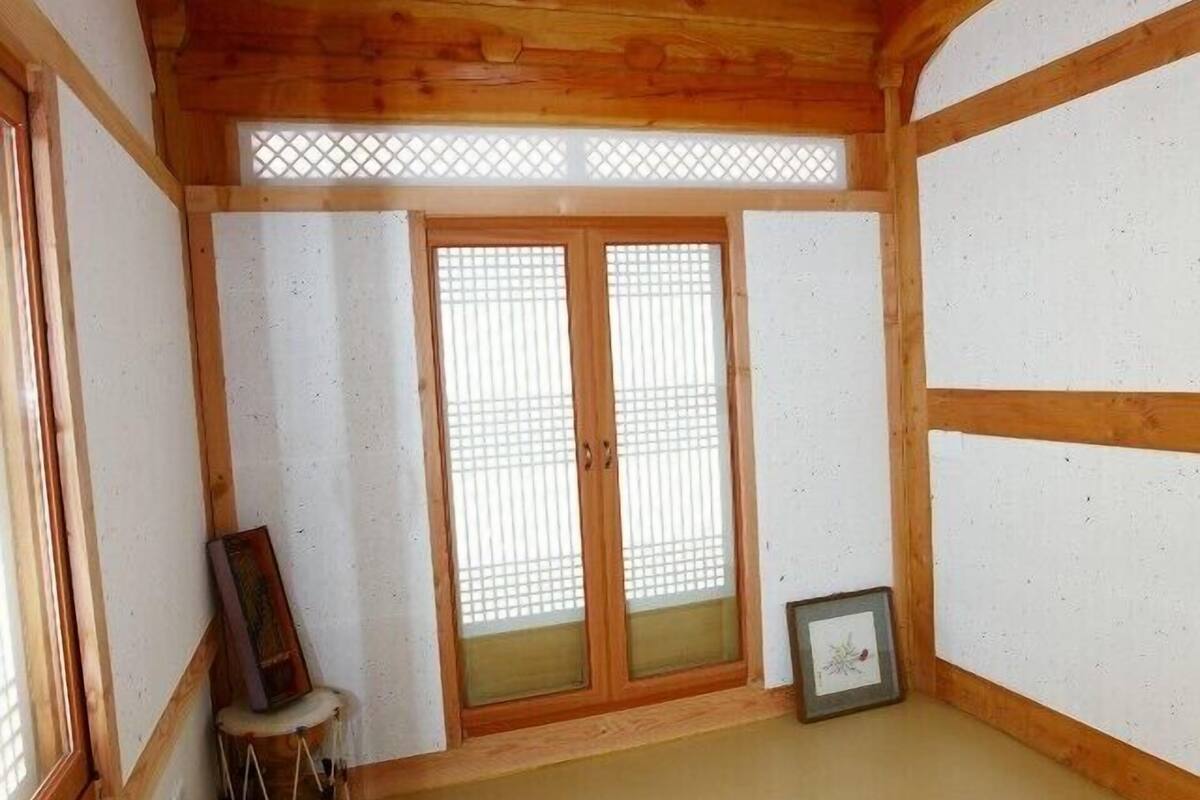 A traditional Japanese room with tatami flooring, wooden beams, sliding doors, and a small drum.