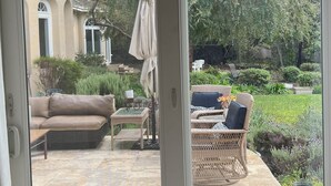 Una habitación con puerta de vidrio corredera que da a un patio exterior.
