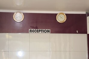 Welcome to the reception area, featuring two classic wall clocks and a prominent 'RECEPTION' sign.
