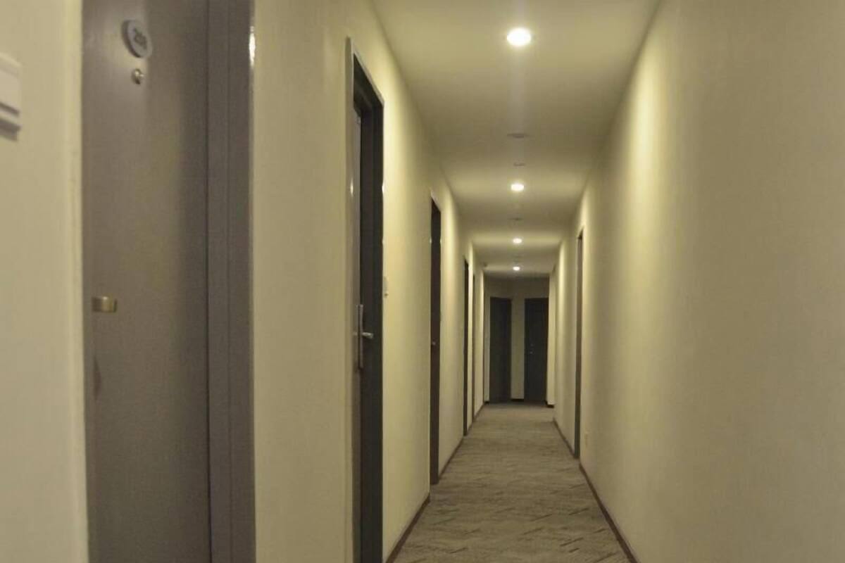 A long, narrow hallway with doors on both sides, leading to rooms.