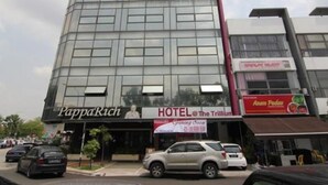 Un hôtel doté d’une façade moderne en verre, d’une enseigne « PappaRich » et d’une autre enseigne indiquant « HÔTEL @ The Trillium ».