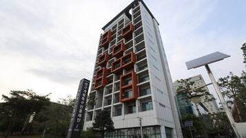 Un immeuble moderne de grande hauteur, doté d’une façade originale caractérisée par des motifs géométriques et des balcons.