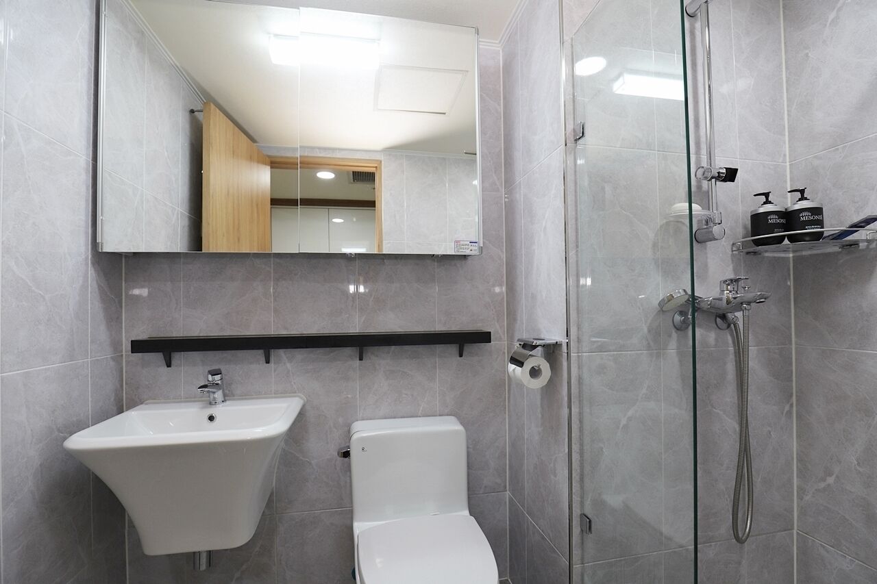 A modern bathroom with a sink, toilet, and glass-enclosed shower.