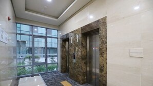 A modern elevator with marble walls and a glass elevator door. - Daejeon I-Hotel (Daejeon)