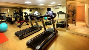 A gym with treadmills, exercise balls, and weight machines. - Hotel Citrus Prime (Raipur)