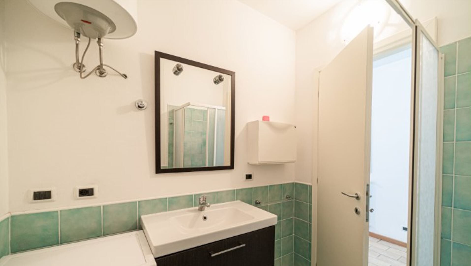 Ein Badezimmer mit Waschbecken, Spiegel und Dusche.