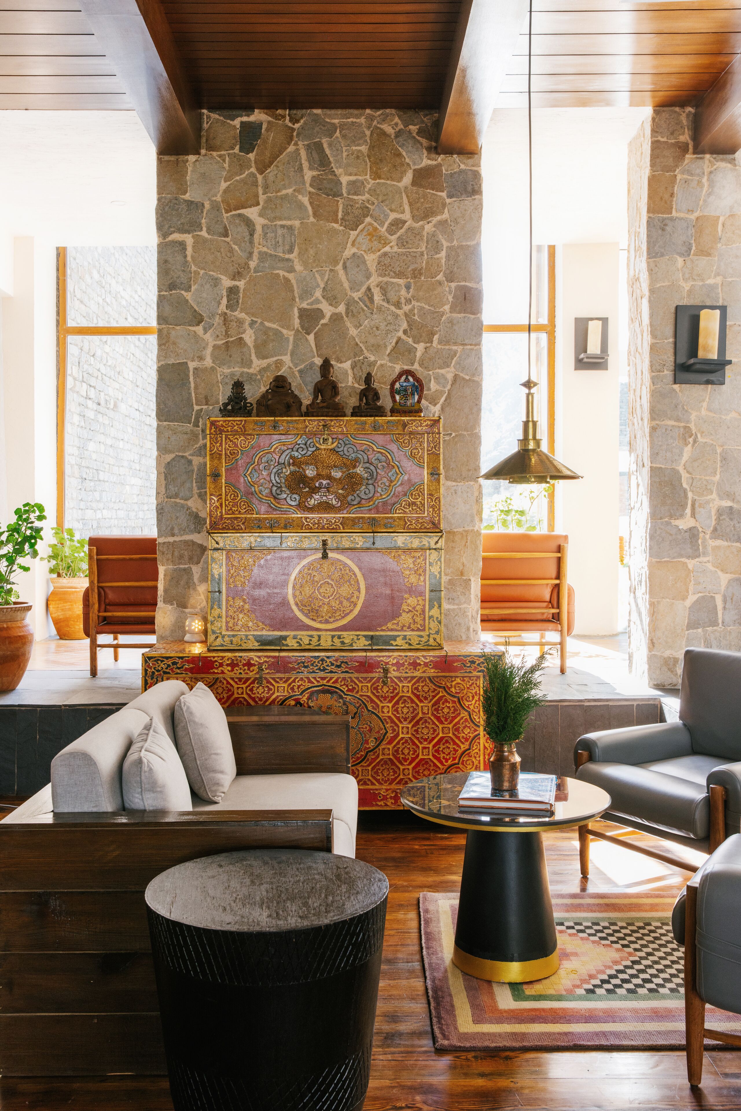 A cozy living room with a stone fireplace, a sofa, a coffee table, and a lamp.