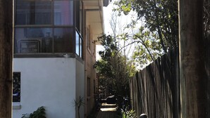 A wooden pathway leading to a building with a 'WELCOME' sign and the number '5' above it. - XYL seaside home stay (Caloundra)