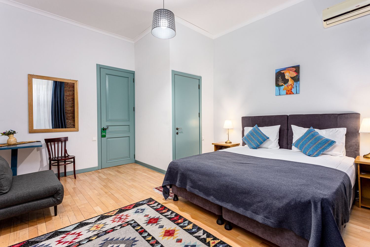 Un dormitorio con cama, escritorio, silla y puerta.