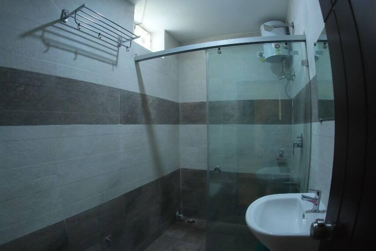 A bathroom with a toilet, a sink, and a glass shower enclosure.