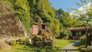 A rustic stone building with a red-tiled roof, surrounded by lush greenery and a stone pathway leading to it. - Wonderful private villa for 4 people with WIFI and TV (Massa)