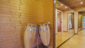 Ein Zimmer mit Holzboden, zwei große Trommeln an der Wand, einer Glastrennwand und einem angrenzenden Flur.