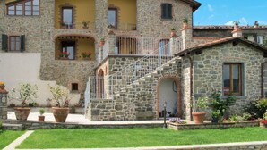 A stone building with a yellow facade, multiple windows, and balconies. - Lovely apartment for 6 guests with private pool, WIFI, A/C, TV, terrace and pets allowed (Lugliano)