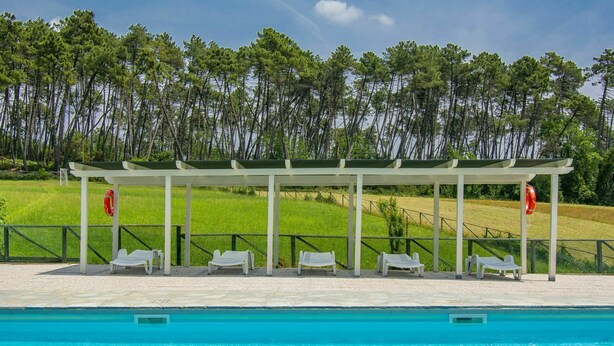 Une piscine dotée d’un espace de repos couvert et de bouées de sauvetage.