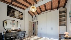 A bedroom with a bed, dresser, wardrobe, and a large mirror. - Wonderful private villa for 4 people with A/C, WIFI, TV, patio and pets allowed (Lucca)