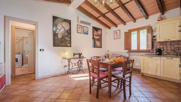 A spacious kitchen with wooden beams, a dining area with a vintage sewing machine, and a chandelier. - Wonderful private villa for 4 people with A/C, WIFI, TV, patio and pets allowed (Lucca)