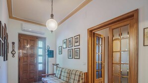 En hall med en dörr av trä, en soffa och en väggklocka.