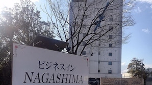 Cartell de Nagashima amb un edifici modern al fons.