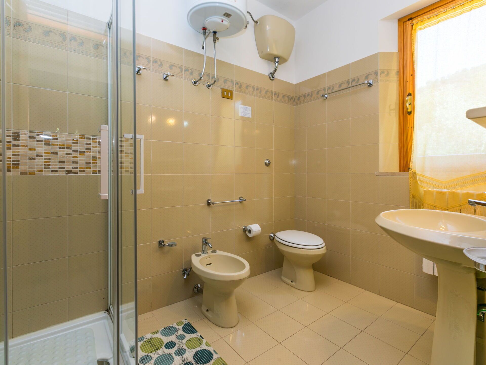 A bathroom with a shower, bidet, toilet, and sink.