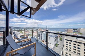A balcony with two lounge chairs and a city view. - Vibe Hotel Hobart (Hobart)