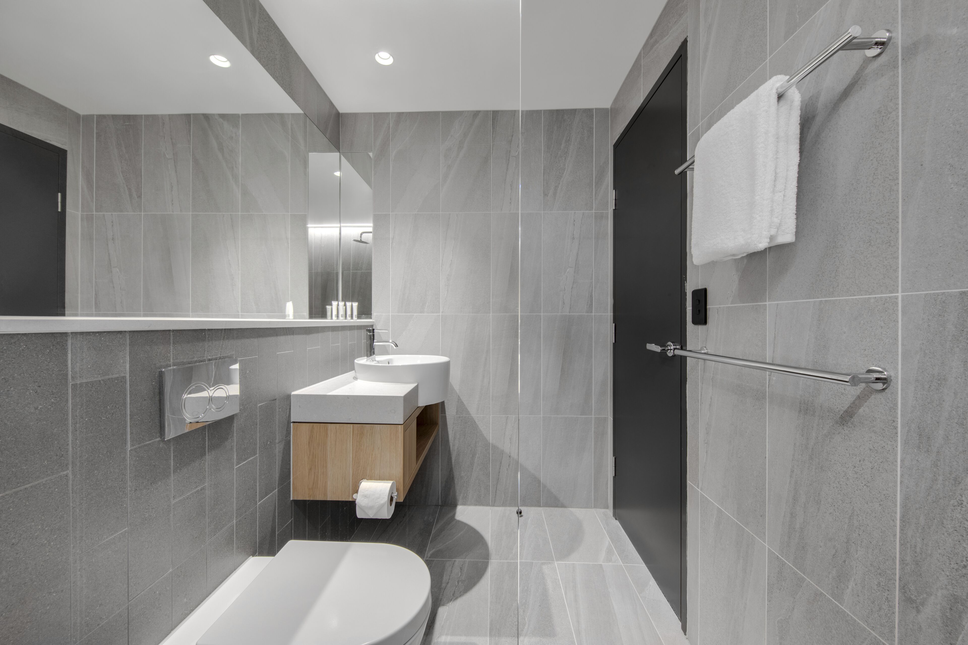 A modern bathroom with a bathtub, a sink, and a mirror.