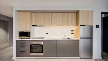 A modern kitchen with built-in appliances, wooden cabinets, and a stainless steel refrigerator.