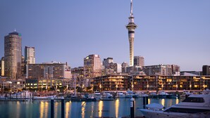 A marina with boats docked, a prominent tower, and a city skyline with various buildings. - Travelodge Hotel Auckland Wynyard Quarter (Auckland)
