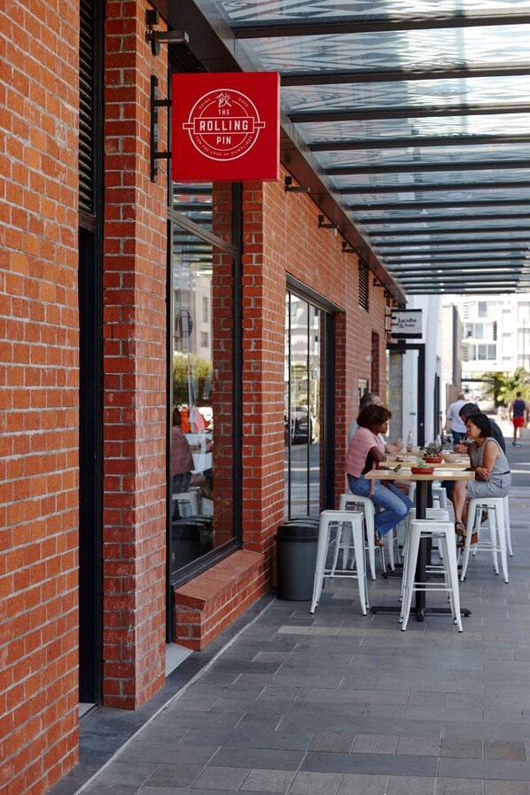A brick building with a red sign reading "The Rolling Pin."