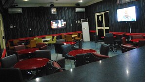 A restaurant with booths and tables, a television, and a door marked "PUSH". - Tuscany Suites (Port Harcourt)