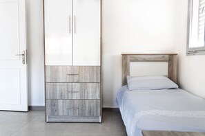A bedroom with a bed, a wardrobe, and a door.