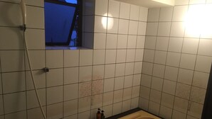 A small bathroom with white tiles, a shower, a bathtub, and a window. - Osaka Grand Hotel (Higashi-osaka)