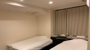 A hotel room with two single beds, a desk with a telephone, and a window with curtains. - Osaka Grand Hotel (Higashi-osaka)