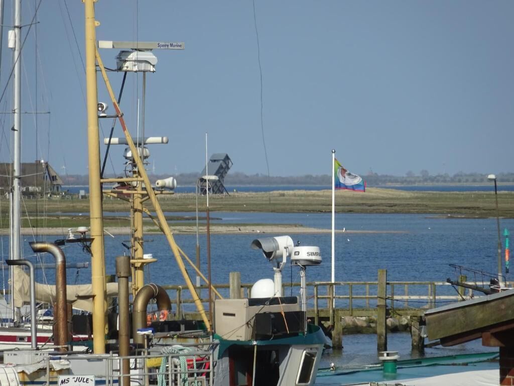 A marina with boats docked, a flag, and a clear sky.