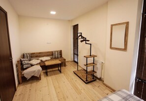A room with a wooden bench, a coat rack, a mirror, and a radiator.