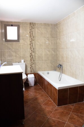 A bathroom with a bathtub, toilet, and sink. - Old City Stylish 4BR by Ahlan Hospitality (Nazareth)