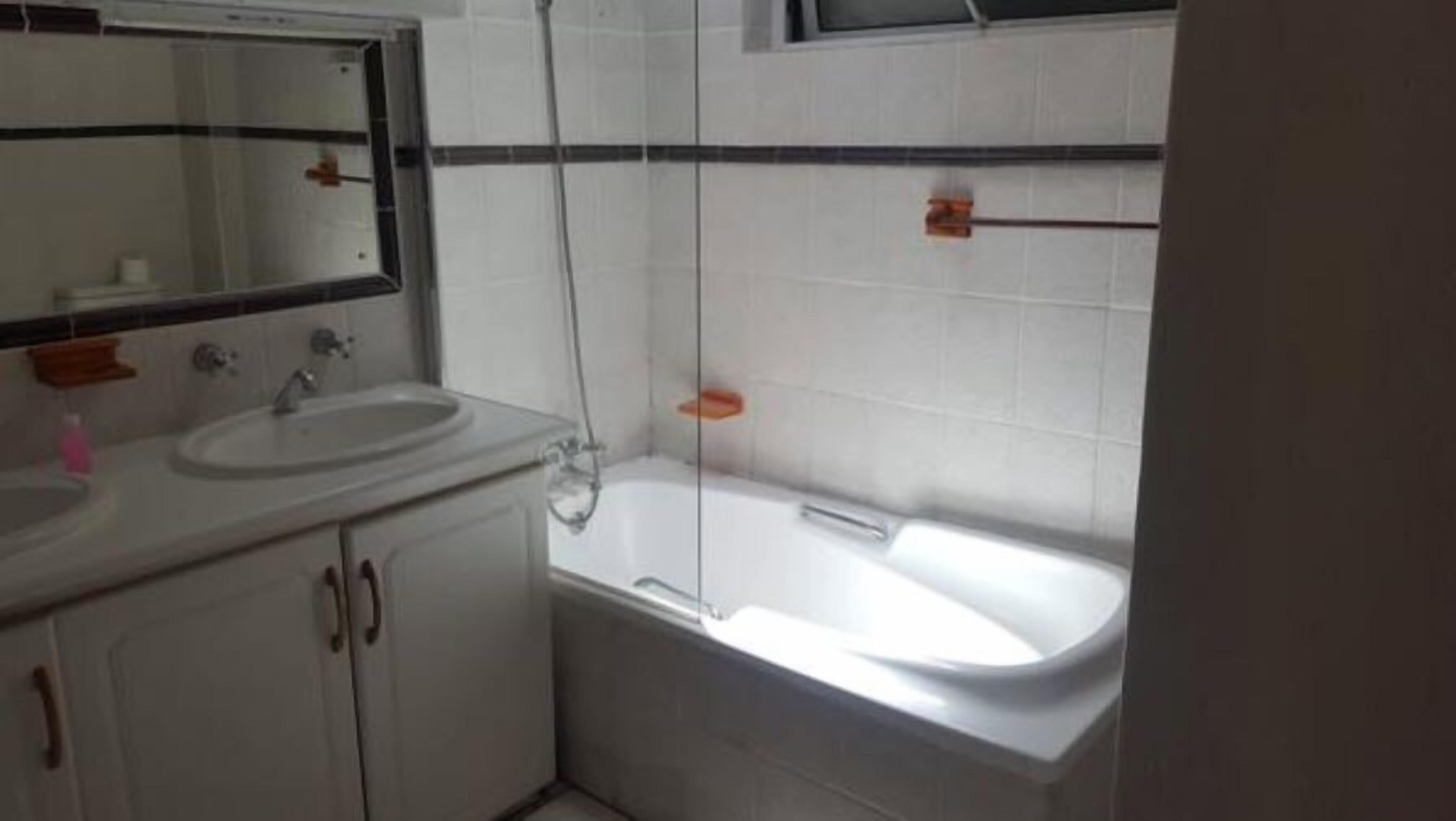 Une salle de bain avec un lavabo, un miroir et une baignoire.