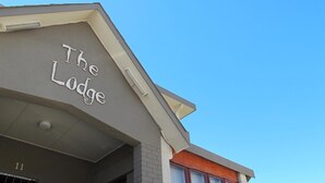 A building with a sign reading "The Lodge" on the facade. - The Lodge Strand (Cape Town)