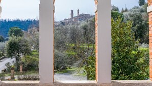 A view through a white-framed archway overlooking a hillside with a historic building and trees. - Wonderful private villa for 11 guests with WIFI, TV, balcony and pets allowed (Sinalunga)