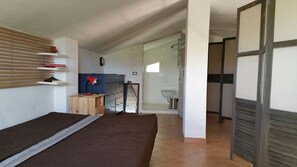 A bedroom with a bed, a desk with a chair, a wardrobe, and a bathroom with a shower. - Jabia Beach House - Villa on the Beach - Private Beach (Castelvetrano)