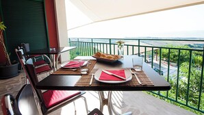 Un balcón con una mesa para dos, un bol de croissants y vistas al paisaje.