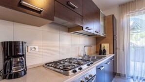 Une cuisine moderne équipée d’une cuisinière à gaz, d’une machine à café et d’un évier.
