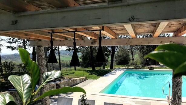 An outdoor pool area with a table set for dining, surrounded by greenery and overlooking a pool. - Welcome at Poggio Cantarello Country Home Tuscany (Chiusi)