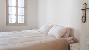 A bedroom with a large bed, a window, and a door. - Heart of Old city 3BR by Ahlan Hospitality (Nazareth)