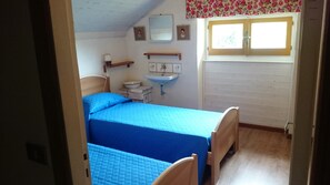 Une chambre à coucher comprenant un lit, une table de chevet, un miroir, une fenêtre et une étagère fixée au mur.