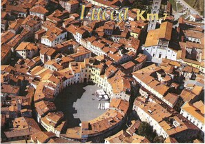 An aerial view of a historic town with tightly packed buildings, a central square, and a prominent tower. - Villa In Lucca Placed in a Residential Area, all Services Nearby (Capannori)