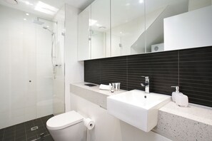 Apartamento executivo | Banheiro | Chuveiro, secador de cabelo, toalhas de banho, papel higiênico